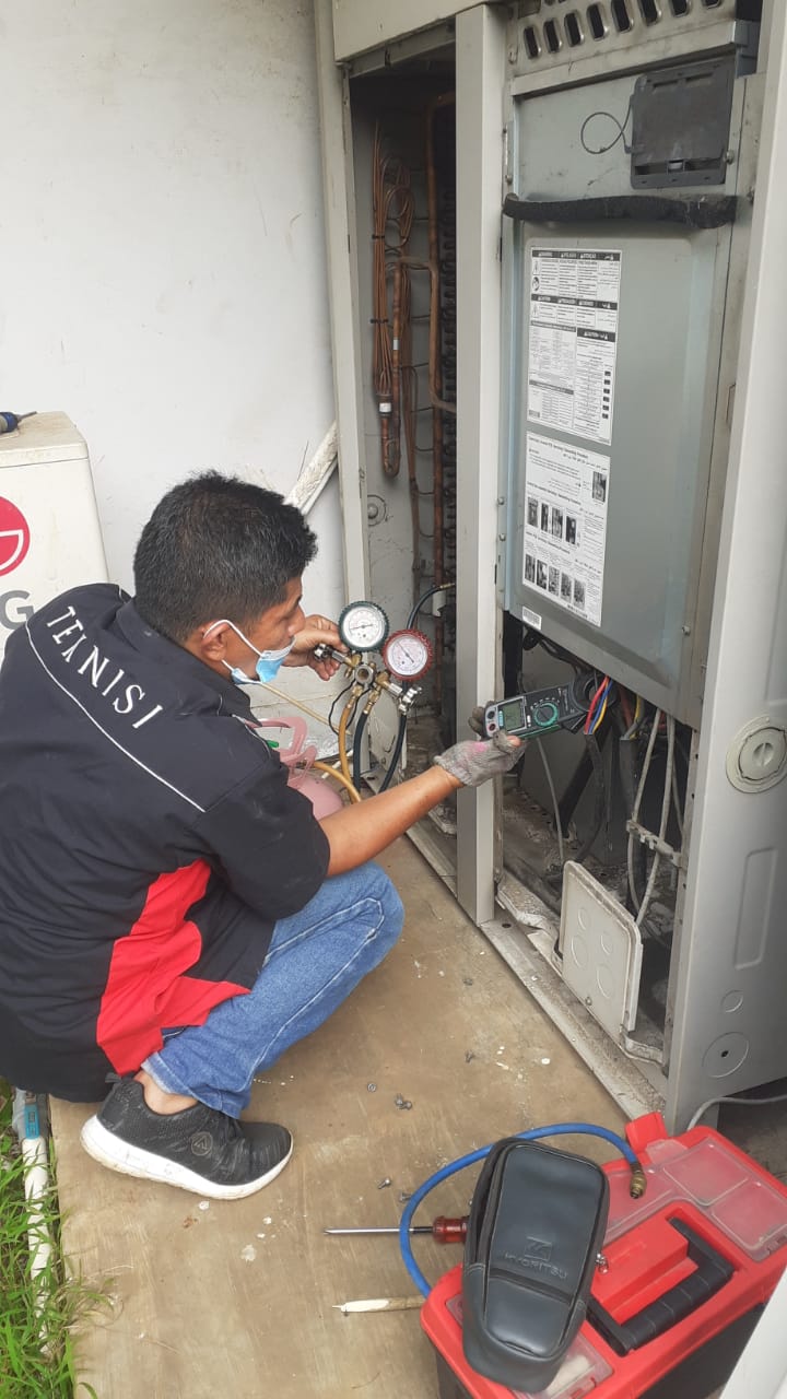 Teknisi Riftek Aircond memeriksa panel unit AC